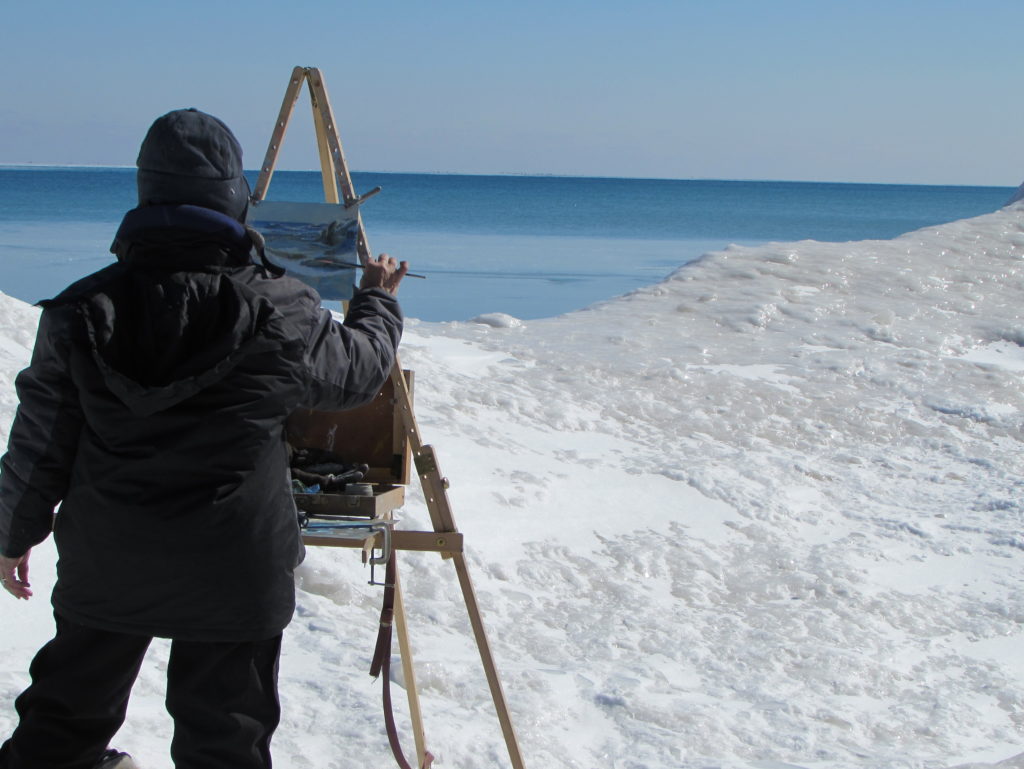 Lynn Rix painting along the frozen shore of Lake Michigan