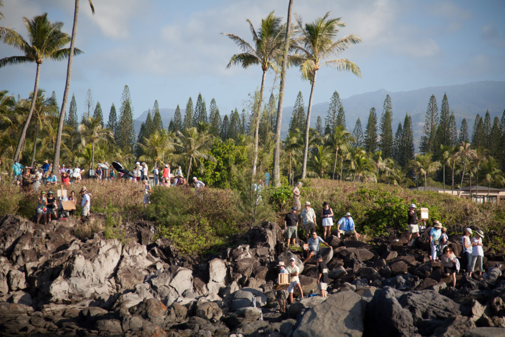 Artists paint along a rocky coastline in Maui during a previous year’s edition of the Maui Plein Air Painting Invitational.