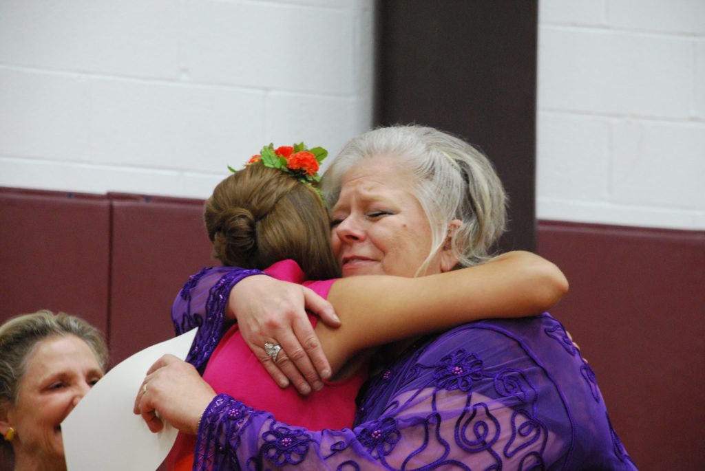 Terry Stanley hugs a student during the graduation ceremony of the Western Art Academy.