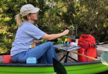 Artist painting outdoors in a canoe