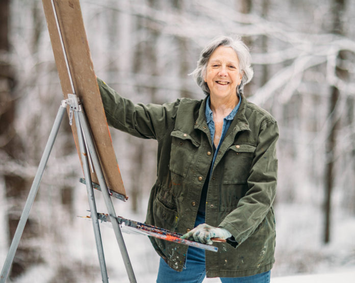 Artist Cynthia Rosen painting outside in snowy Vermont.