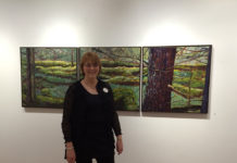 Woman artist standing in front of her painting.
