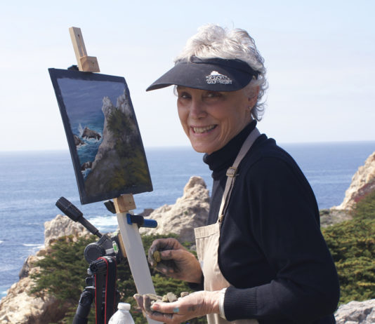 Artist Spotlight: Mary McIntosh Photo of a female artist painting on a bluff by the ocean