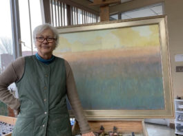Woman artist in front of a painting on an easel