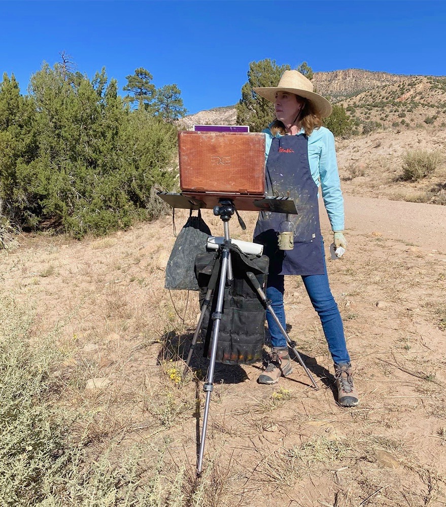 Female artist painting outdoors in the desert