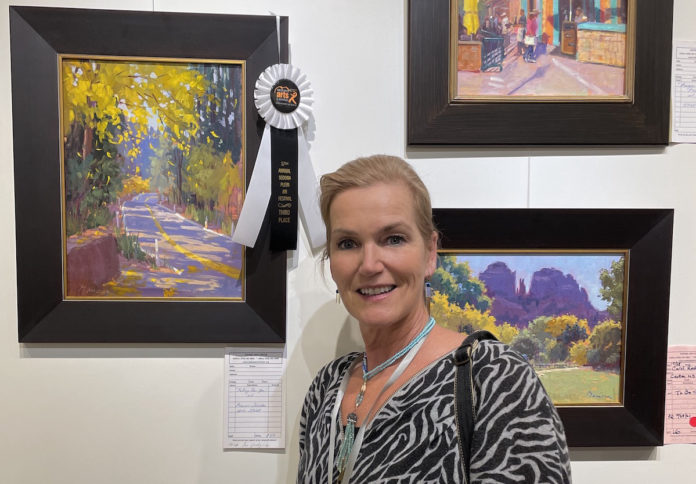 Artist Manon Sander with her oil painting at the Sedona Plein Air Festival