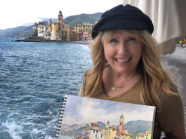 picture of artist Cindy Briggs holding her painting