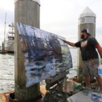 Ryan Jensen paints on the docks near his home in Northern California.