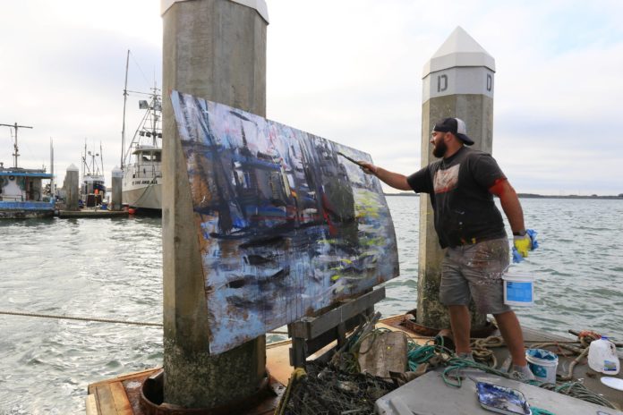 Ryan Jensen paints on the docks near his home in Northern California.