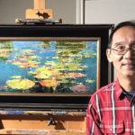 artist posing with his most recent painting propped on an easel