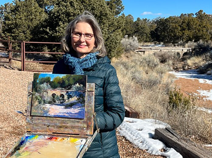 Artist posing with her painting en plein air