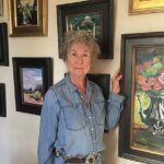 Artist posing with her paintings