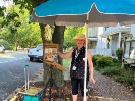 Rhonda Ford set up to paint in front of The Treasure Chest in Oxford during Plein Air Easton.