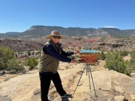 photo of artist painting en plein air in the desert landscape