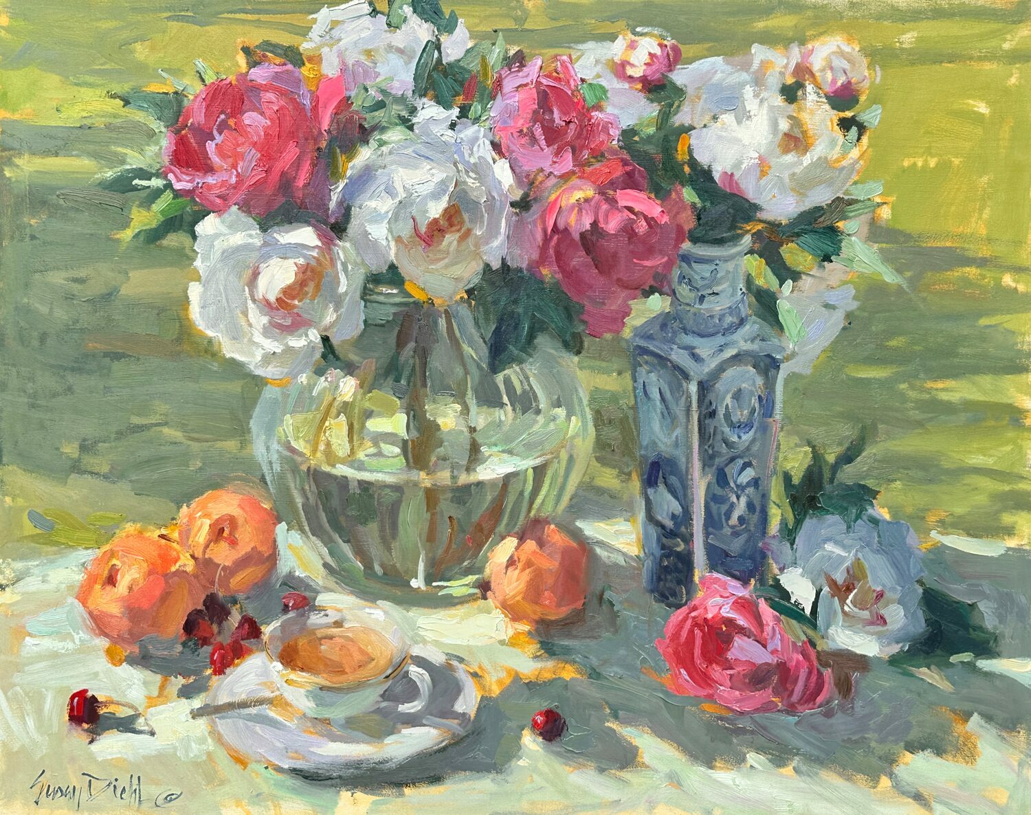 A still life painting showing a glass vase with pink and white flowers, a blue patterned vase, several peaches, cherries, and a teacup on a saucer, all set on a sunlit table with a soft green background. 15th Annual PleinAir Salon Art Competition