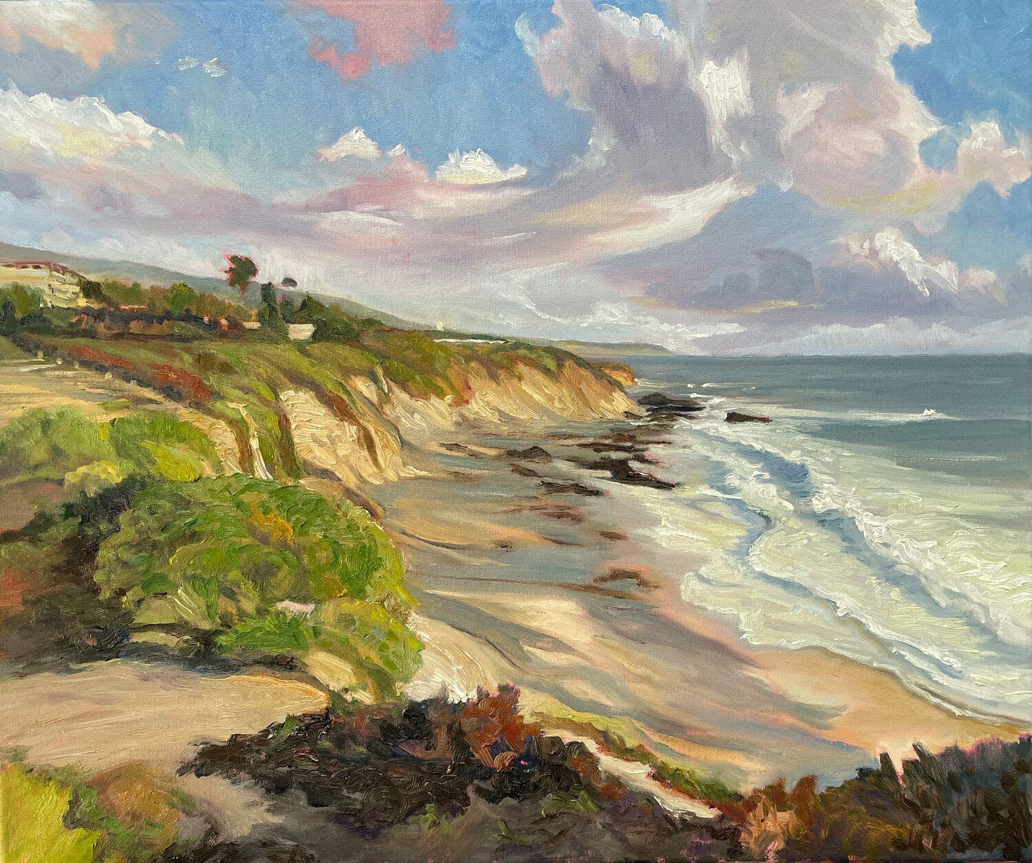 A colorful painting of a coastal landscape with cliffs, green vegetation, and waves crashing onto a sandy beach under a sky with clouds and patches of blue. 15th Annual PleinAir Salon Art Competition