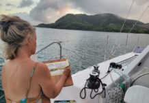 Roxy Podlogar painting Malakati Village from the cockpit of her sailboat, 'Sky Pond'
