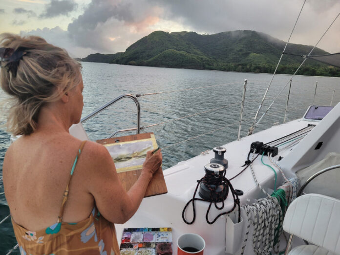 Roxy Podlogar painting Malakati Village from the cockpit of her sailboat, 'Sky Pond'