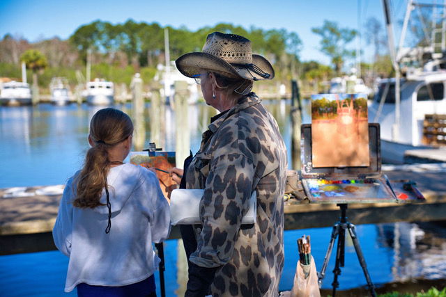 Forgotten Coast en Plein Air - Michelle Held assists a student art painter at the Millpond in Apalachicola.