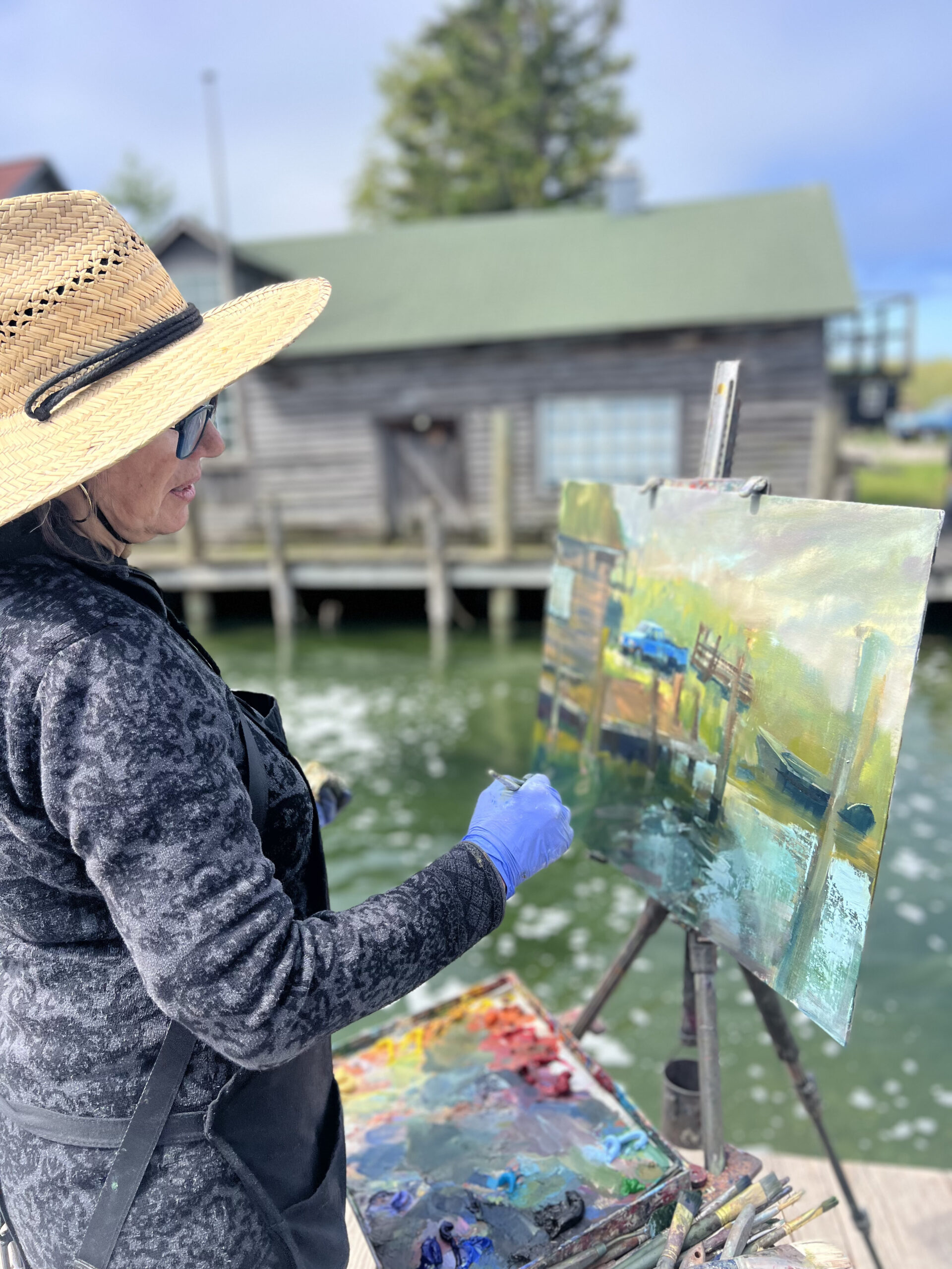 Lyudmila Tomova Clark painting “Blue Truck Morning” at Fishtown in Leelanau Peninsula, Michigan.