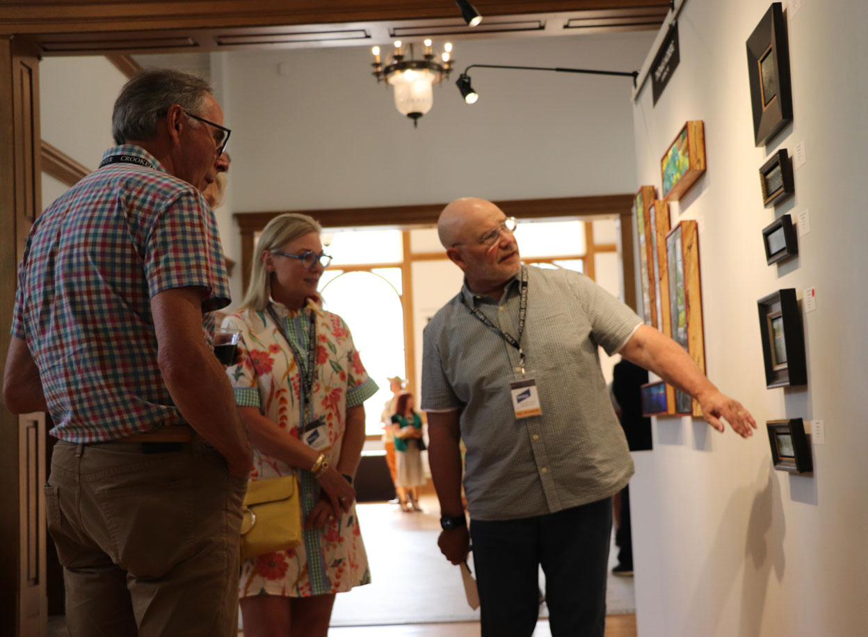 Collector and Sponsor Kurt Rivard (right) reviewing works created by Crista Pisano during Paint Grand Traverse. Photo credit: Judy Kelly