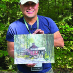 INSPIRING ARTIST: The Transformative Experience of Painting America Plein air watercolor artist Richie Vios holding a painting